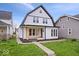 Charming two-story home with a modern design, large windows, inviting porch, and well-manicured lawn at 923 E Pleasant Run Pkwy S Dr, Indianapolis, IN 46203