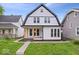 Charming two-story home with a modern design, large windows, inviting porch, and well-manicured lawn at 923 E Pleasant Run Pkwy S Dr, Indianapolis, IN 46203