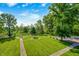 Manicured backyard boasts lush lawn, mature trees, and pond views, creating a serene outdoor setting at 9600 N 500 E, Pendleton, IN 46064