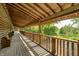 Long, covered wooden deck features natural wood architecture, with views of a lush green landscape at 9600 N 500 E, Pendleton, IN 46064