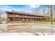 Long log home with wrap around porch and large gravel driveway at 9600 N 500 E, Pendleton, IN 46064