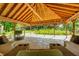 Relaxing gazebo interior featuring comfortable seating, a television, and a stunning stone floor with views of the property at 9600 N 500 E, Pendleton, IN 46064