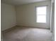 Bright bedroom with neutral carpet, white walls, and a large window at 1217 Legacy Ln, Indianapolis, IN 46234