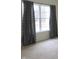 Bedroom featuring large window, neutral walls, carpet flooring, and elegant gray patterned curtains at 1217 Legacy Ln, Indianapolis, IN 46234