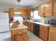 Functional kitchen features wood cabinetry, white countertops, and essential appliances for easy meal preparation at 1217 Legacy Ln, Indianapolis, IN 46234