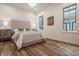 Bright bedroom with a light beige upholstered bed, hardwood floors, and large windows at 1561 N Park Ave, Indianapolis, IN 46202