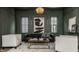 Sophisticated Gathering room boasts a dark green accent wall, leather sofa, and two armchairs at 1561 N Park Ave, Indianapolis, IN 46202