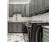 Modern laundry room with green cabinets, granite countertops, and new appliances at 1561 N Park Ave, Indianapolis, IN 46202