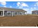 Backyard of a gray home under construction, showing the exterior and new landscaping at 16964 Cattle Hollow Ln, Noblesville, IN 46060