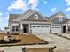 Charming townhome features a two-car garage, gray siding, stone accents, and beautifully manicured landscaping at 16964 Cattle Hollow Ln, Noblesville, IN 46060