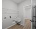 Functional laundry room with utility sink and storage shelf at 16964 Cattle Hollow Ln, Noblesville, IN 46060