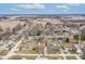 A distant aerial shot captures a residential neighborhood amid open fields on a partly cloudy day at 2338 Malibu Ct, Anderson, IN 46012