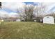 Expansive backyard with a variety of structures, trees, lawn, and space for many activities at 2338 Malibu Ct, Anderson, IN 46012