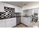 Modern kitchen featuring white cabinets, stainless steel appliances, and checkered backsplash at 2338 Malibu Ct, Anderson, IN 46012
