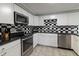 Updated kitchen featuring white cabinets, stainless steel appliances, and black countertops at 2338 Malibu Ct, Anderson, IN 46012