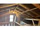 Unfinished attic space with exposed wooden beams and a window at 302 E Cowing Dr, Muncie, IN 47303
