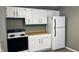 White kitchen with wood countertops and black appliances at 302 E Cowing Dr, Muncie, IN 47303