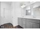 Elegant bathroom featuring a double vanity, gray cabinets, and a large mirror at 4416 Voyageur Way, Carmel, IN 46074