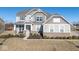 Two-story house with gray siding, brick accents, and a landscaped lawn at 4416 Voyageur Way, Carmel, IN 46074