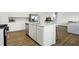 White kitchen with island, stainless steel appliances, and hardwood floors at 5904 Sunstone Rd, Indianapolis, IN 46239