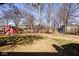 Spacious backyard with a red storage shed and mature trees offering plenty of shade and privacy at 6826 E 65Th St, Indianapolis, IN 46220