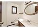 Bathroom features a vintage mirror, a wood vanity, and a toilet with a clean, classic design at 6826 E 65Th St, Indianapolis, IN 46220