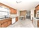 Eat-in kitchen with wood cabinets, a white dishwasher, and a view into the connected living space at 6826 E 65Th St, Indianapolis, IN 46220