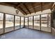 Bright sunroom with large windows showcasing backyard views, enhanced by a rustic ceiling and an elegant light fixture at 6826 E 65Th St, Indianapolis, IN 46220