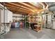 Functional basement features exposed wooden beams, painted floor, and organized shelving units at 7837 Dean Rd, Indianapolis, IN 46240