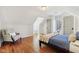Bedroom with hardwood floors, dormer window, cozy chair, and a comfortable bed covered in blue bedding at 7837 Dean Rd, Indianapolis, IN 46240