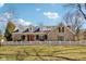 Charming stone home featuring a bright red door, dormer windows and a white picket fence at 7837 Dean Rd, Indianapolis, IN 46240