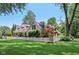 Charming stone home with a well-manicured lawn and white picket fence in a lush, green neighborhood at 7837 Dean Rd, Indianapolis, IN 46240