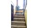 Carpeted staircase with wooden railing and a plant on the landing at 917 E 34Th St, Indianapolis, IN 46205