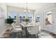 Bright dining room with a modern chandelier, marble table, and a view of the neighborhood at 11436 Mossy Ct # 102, Fishers, IN 46037