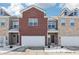 Brick townhouse with 2-car garage and snow-covered landscaping at 11436 Mossy Ct # 102, Fishers, IN 46037