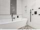 Well-lit bathroom with sleek white bathtub, textured white tiles, and modern shower fixtures at 1224 Keystone Ave, Indianapolis, IN 46201