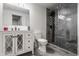 Modern bathroom boasts a sleek vanity, decorative mirror, toilet, and glass-enclosed shower with striking dark tile at 1224 Keystone Ave, Indianapolis, IN 46201