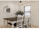 Dining area featuring a wood table, six chairs, modern light fixture, and bright window at 1224 Keystone Ave, Indianapolis, IN 46201