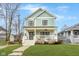 Charming two-story home featuring a welcoming front porch, well-manicured lawn, and beautiful architectural details at 1224 Keystone Ave, Indianapolis, IN 46201
