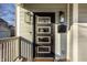 A stylish black front door featuring sidelights and modern hardware is complimented by lantern sconces and muted siding at 1224 Keystone Ave, Indianapolis, IN 46201