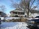 Tan house with porch, steps, and snow-covered yard at 1300 W 13Th St, Muncie, IN 47302