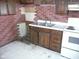 Kitchen with old cabinets and exposed brick at 1300 W 13Th St, Muncie, IN 47302
