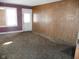 Living room with wood paneling and dirty carpet at 1300 W 13Th St, Muncie, IN 47302