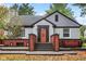 Charming brick home featuring a cozy front entry and well-manicured landscaping at 233 W Westfield Blvd, Indianapolis, IN 46208