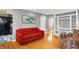 Cozy living room with a bright red couch and hardwood floors, perfect for relaxing or entertaining at 233 W Westfield Blvd, Indianapolis, IN 46208