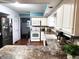White kitchen with stainless steel appliances and wood floors at 3163 S 25 E, Shelbyville, IN 46176