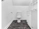 Simple bathroom with toilet, vanity, and dark-grey floor tiles at 320 W 6Th St, Muncie, IN 47302