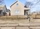 Beige house with a front porch and chain link fence at 320 W 6Th St, Muncie, IN 47302