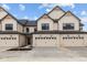 Townhouse showcasing a two-car garage, modern design elements, and tidy landscaping under a blue sky at 4183 Douro Trl, Westfield, IN 46062