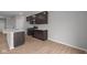 Modern kitchen with dark cabinets, a center island sink, stainless steel appliances, and wood flooring at 4183 Douro Trl, Westfield, IN 46062